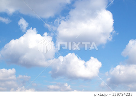 Blue sky with fluffy white clouds on a bright summer day over a peaceful horizon Blue sky with fluffy white clouds on a bright summer day over a peaceful horizon 139754223