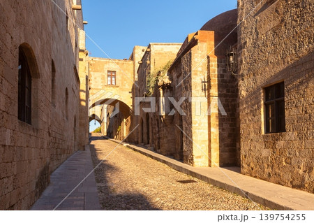 Narrow stone street with arches in Rhodes Old Town Greece 139754255