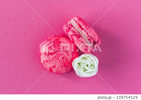 Two pink French macarons with white flower. Flat lay, close up. 139754529