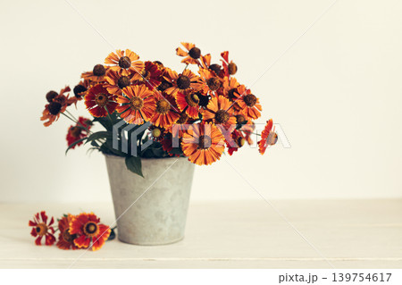 Autumn bouquet of bright flowers (Helenium autumnale) in a vintage pot. Concept for autumn background or postcard. Autumn bouquet of bright flowers (Helenium autumnale) in a vintage pot. Concept for autumn background or postcard. 139754617
