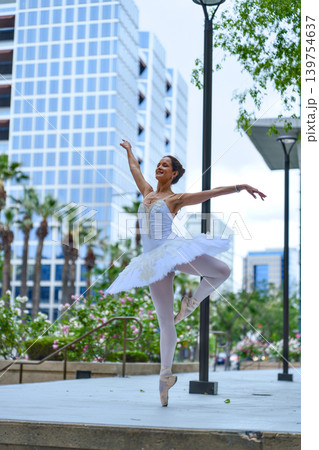 Ballerina posing on pointe in modern city plaza Ballerina posing on pointe in modern city plaza 139754637