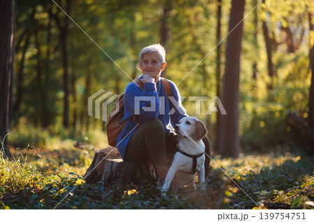 Senior woman with dog on walk outdoors in nature. 139754751