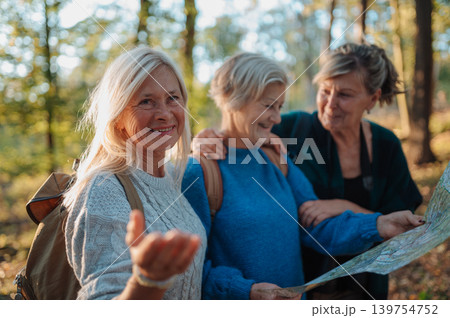 Mature female friends exploring nature together with map on hiking trip. 139754752