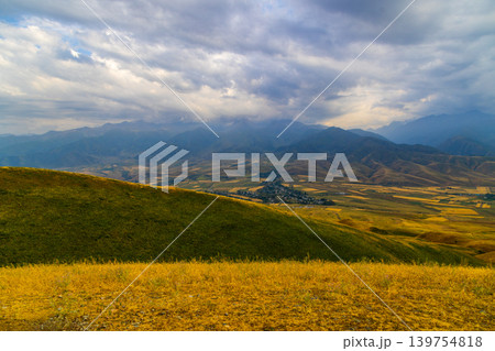Dramatic mountain landscape overlooking rural valley and settlement Dramatic mountain landscape overlooking rural valley and settlement 139754818