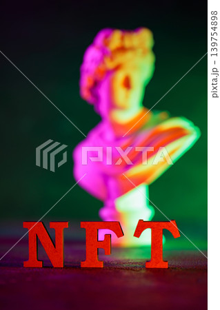 NFT red letters with blurred classical sculpture bust and colorful neon gradient lighting NFT red letters with blurred classical sculpture bust and colorful neon gradient lighting 139754898