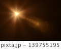 Golden lens flare light leak effect with sunburst on black background 139755195