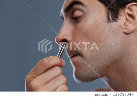 Nose hair, cleaning and man with tweezers and pain from plucking in studio background or mockup. Beauty, epilation and person with facial grooming routine and treatment for self care with tools 139755347