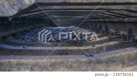 Detailed view of corroded railway elements with ballast and fasteners in moody urban setting Detailed view of corroded railway elements with ballast and fasteners in moody urban setting 139756161