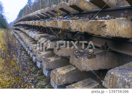 Stacked weathered concrete sleepers in industrial yard prepared for track replacement tasks 139756166