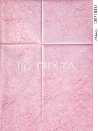 Macro texture of pink handmade mulberry paper with visible silk fibers. Folded washi paper background with creases and a torn paper edge effect. Paper background with creases forming a cross pattern. 139756352