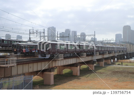大阪の都市風景を背景にずらりと線路が並ぶ新淀川橋梁を行き交う阪急電車たち 大阪の都市風景を背景にずらりと線路が並ぶ新淀川橋梁を行き交う阪急電車たち 139756754