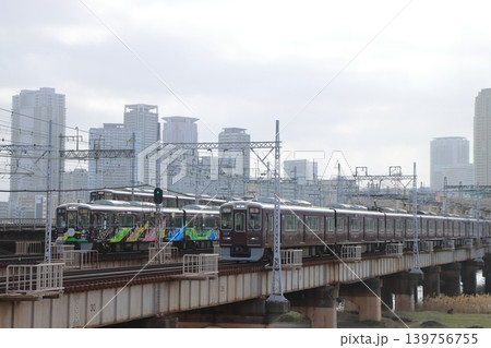 大阪の都市風景を背景にずらりと線路が並ぶ新淀川橋梁を行き交う阪急電車たち 大阪の都市風景を背景にずらりと線路が並ぶ新淀川橋梁を行き交う阪急電車たち 139756755