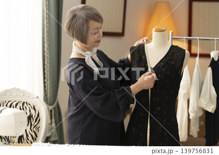 シニア女性のデザイナーがアトリエで洋服を作る 139756831