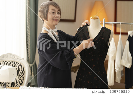 シニア女性のデザイナーがアトリエで洋服を作る シニア女性のデザイナーがアトリエで洋服を作る 139756839