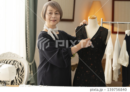 シニア女性のデザイナーがアトリエで洋服を作る シニア女性のデザイナーがアトリエで洋服を作る 139756840