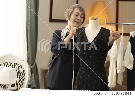 シニア女性のデザイナーがアトリエで洋服を作る シニア女性のデザイナーがアトリエで洋服を作る 139756841