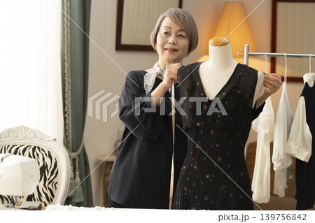 シニア女性のデザイナーがアトリエで洋服を作る シニア女性のデザイナーがアトリエで洋服を作る 139756842