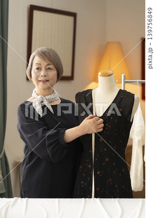 シニア女性のデザイナーがアトリエで洋服を作る シニア女性のデザイナーがアトリエで洋服を作る 139756849
