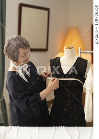 シニア女性のデザイナーがアトリエで洋服を作る シニア女性のデザイナーがアトリエで洋服を作る 139756850