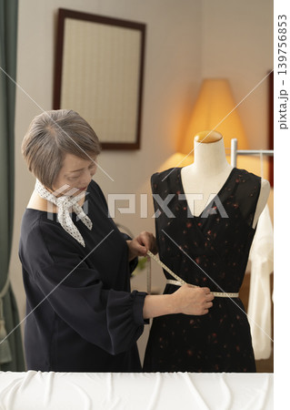 シニア女性のデザイナーがアトリエで洋服を作る シニア女性のデザイナーがアトリエで洋服を作る 139756853