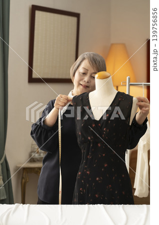 シニア女性のデザイナーがアトリエで洋服を作る シニア女性のデザイナーがアトリエで洋服を作る 139756856