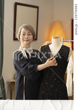 シニア女性のデザイナーがアトリエで洋服を作る シニア女性のデザイナーがアトリエで洋服を作る 139756862