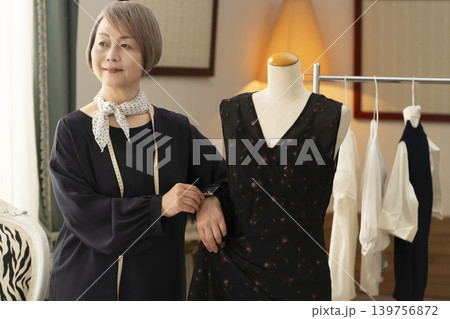 シニア女性のデザイナーがアトリエで洋服を作る 139756872