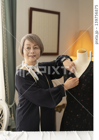 シニア女性のデザイナーがアトリエで洋服を作る シニア女性のデザイナーがアトリエで洋服を作る 139756875