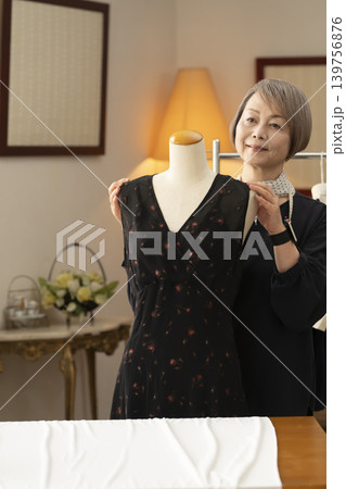 シニア女性のデザイナーがアトリエで洋服を作る 139756876