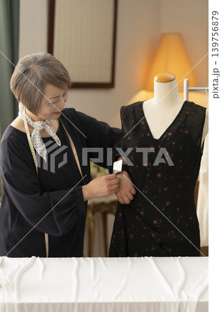 シニア女性のデザイナーがアトリエで洋服を作る シニア女性のデザイナーがアトリエで洋服を作る 139756879