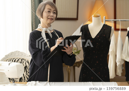 シニア女性のデザイナーがアトリエで洋服を作る 139756889