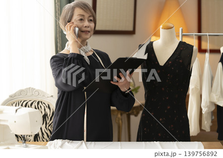 シニア女性のデザイナーがアトリエで洋服を作る シニア女性のデザイナーがアトリエで洋服を作る 139756892