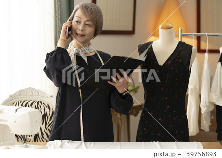 シニア女性のデザイナーがアトリエで洋服を作る シニア女性のデザイナーがアトリエで洋服を作る 139756893