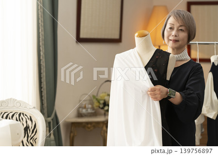 シニア女性のデザイナーがアトリエで洋服を作る 139756897