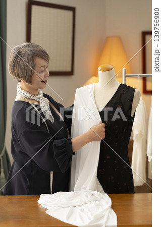 シニア女性のデザイナーがアトリエで洋服を作る シニア女性のデザイナーがアトリエで洋服を作る 139756900