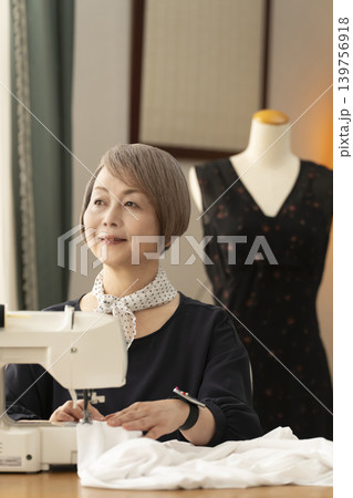 シニア女性のデザイナーがアトリエで洋服を作る 139756918