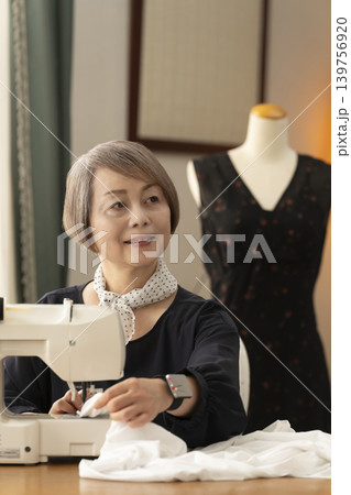 シニア女性のデザイナーがアトリエで洋服を作る シニア女性のデザイナーがアトリエで洋服を作る 139756920
