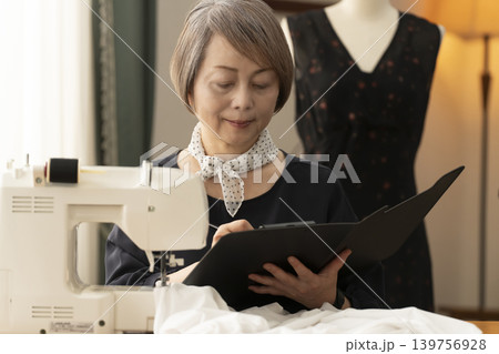 シニア女性のデザイナーがアトリエで洋服を作る シニア女性のデザイナーがアトリエで洋服を作る 139756928