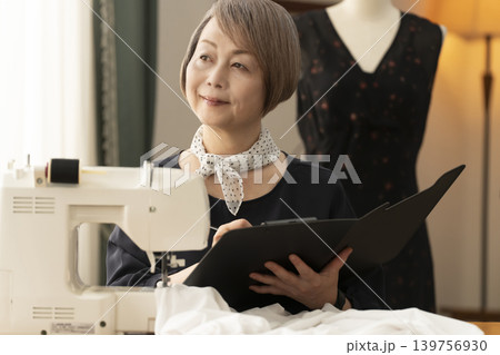 シニア女性のデザイナーがアトリエで洋服を作る 139756930