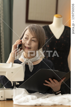 シニア女性のデザイナーがアトリエで洋服を作る シニア女性のデザイナーがアトリエで洋服を作る 139756936