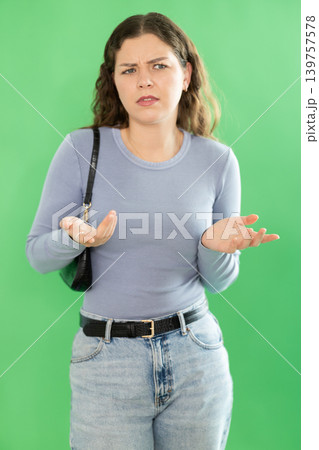 Young woman confused and forgetful in front of green screen Young woman confused and forgetful in front of green screen 139757578