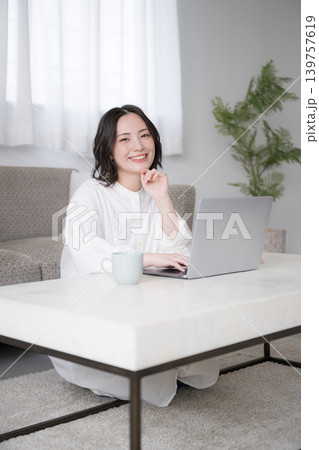 自宅でノートパソコンを使う女性資格勉強や投資を考えるライフスタイル カメラ目線の笑顔 自宅でノートパソコンを使う女性資格勉強や投資を考えるライフスタイル カメラ目線の笑顔 139757619
