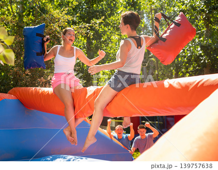Women holding soft pillows and fighting in adventure park Women holding soft pillows and fighting in adventure park 139757638