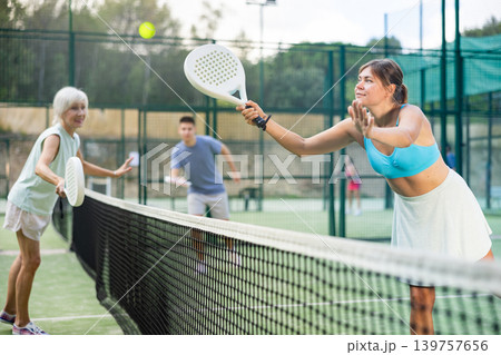 Women playing padel tennis match during training on court Women playing padel tennis match during training on court 139757656