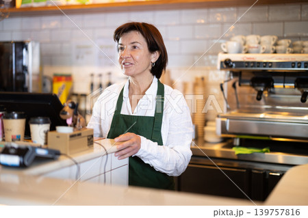 Senior woman salesperson works in cafeteria bakery shop 139757816