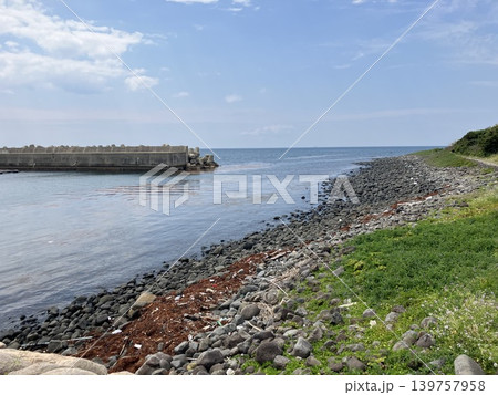 青空の下に広がる岩場海岸と防波堤 139757958
