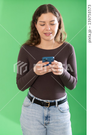 Female person girl scrolls phone screen or types text message Female person girl scrolls phone screen or types text message 139758573