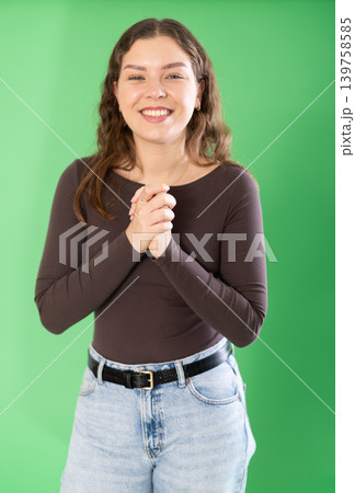 Young woman happy and smiling in front of green screen Young woman happy and smiling in front of green screen 139758585