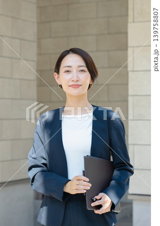 ファイルを持った笑顔のビジネスウーマン ファイルを持った笑顔のビジネスウーマン 139758807