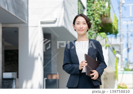 ファイルを持った笑顔のビジネスウーマン ファイルを持った笑顔のビジネスウーマン 139758810